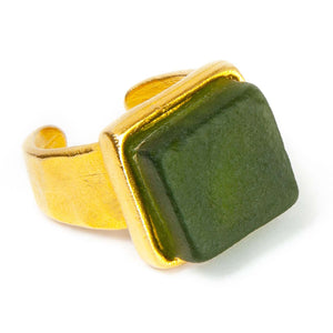 Close up of a dark green recycled glass cocktail ring with a square stone and agold band