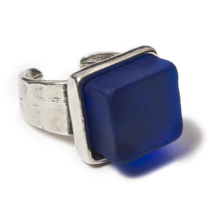 Close up of a dark blue recycled glass cocktail ring with  a square stone and a pewter band