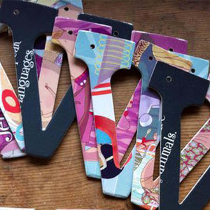 seven designs of the letter "V", placed on exposed wood. Designs feature pages of children's picture books.