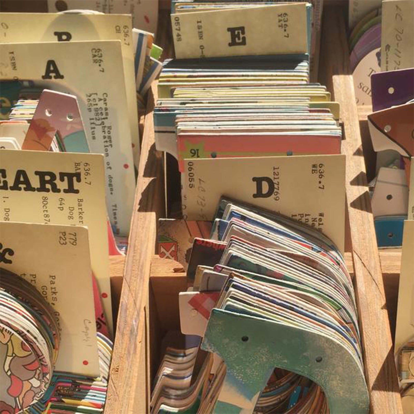 Wooden filing drawer, with various letters. Shows unique style of some letters, indicating no two letters are made the same