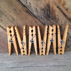 6 clothespins displayed vertically in front of rustic reclaimed wood