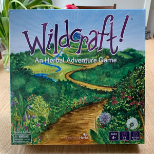 Wildcraft game. board game box. purple text with watercolor painting of vista
