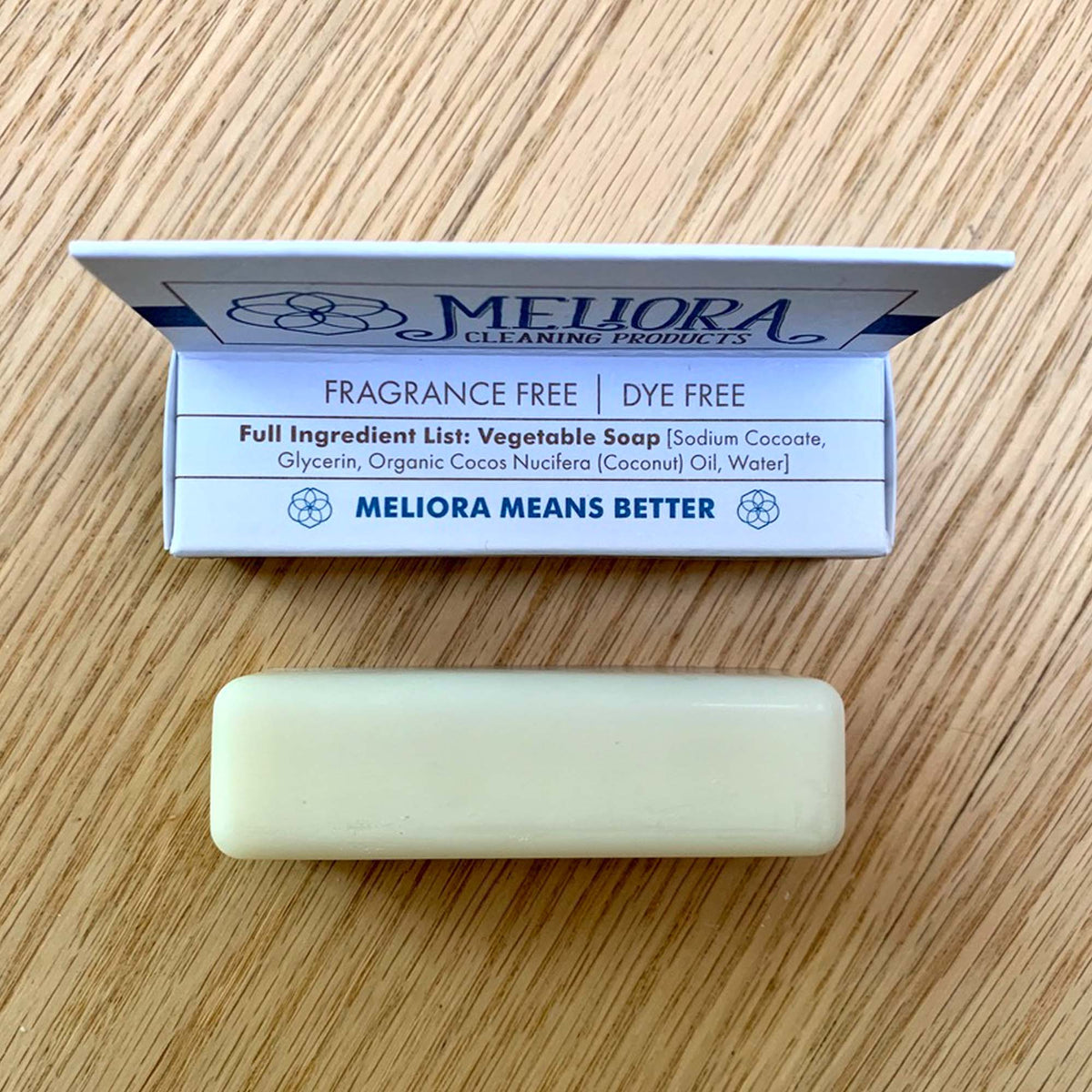 1.7 oz laundry stain removal soap stick package with ingredients list, blue and white, with natural colored stick on wood tabletop