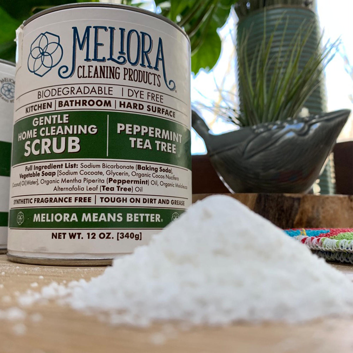 12 oz meliora cleaning scrub can, peppermint tea tree green, soap shavings in foreground