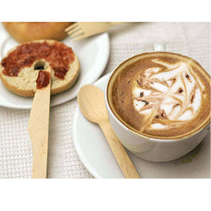 disposable fork knife and spoon, next to cappuccino, bagel with jam