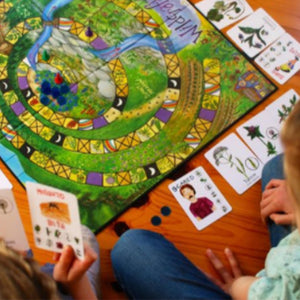 two children playing wildcraft board game with cards surrounding game board