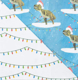 Close up of dinosaur (T-Rex wearing a Santa hat) paper and string holiday lights paper