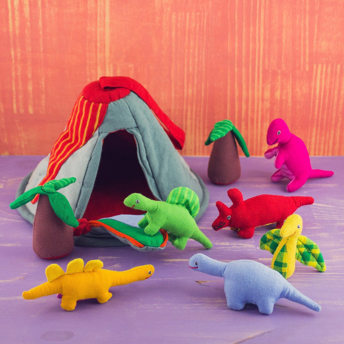 6 soft happy dinosaur toys, two soft palm tree toys, and a soft volcano toy. multicolored