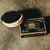 Beechwood brush with boar bristles sitting near black and natural paper box with label for Brooklyn Grooming Beard Brush