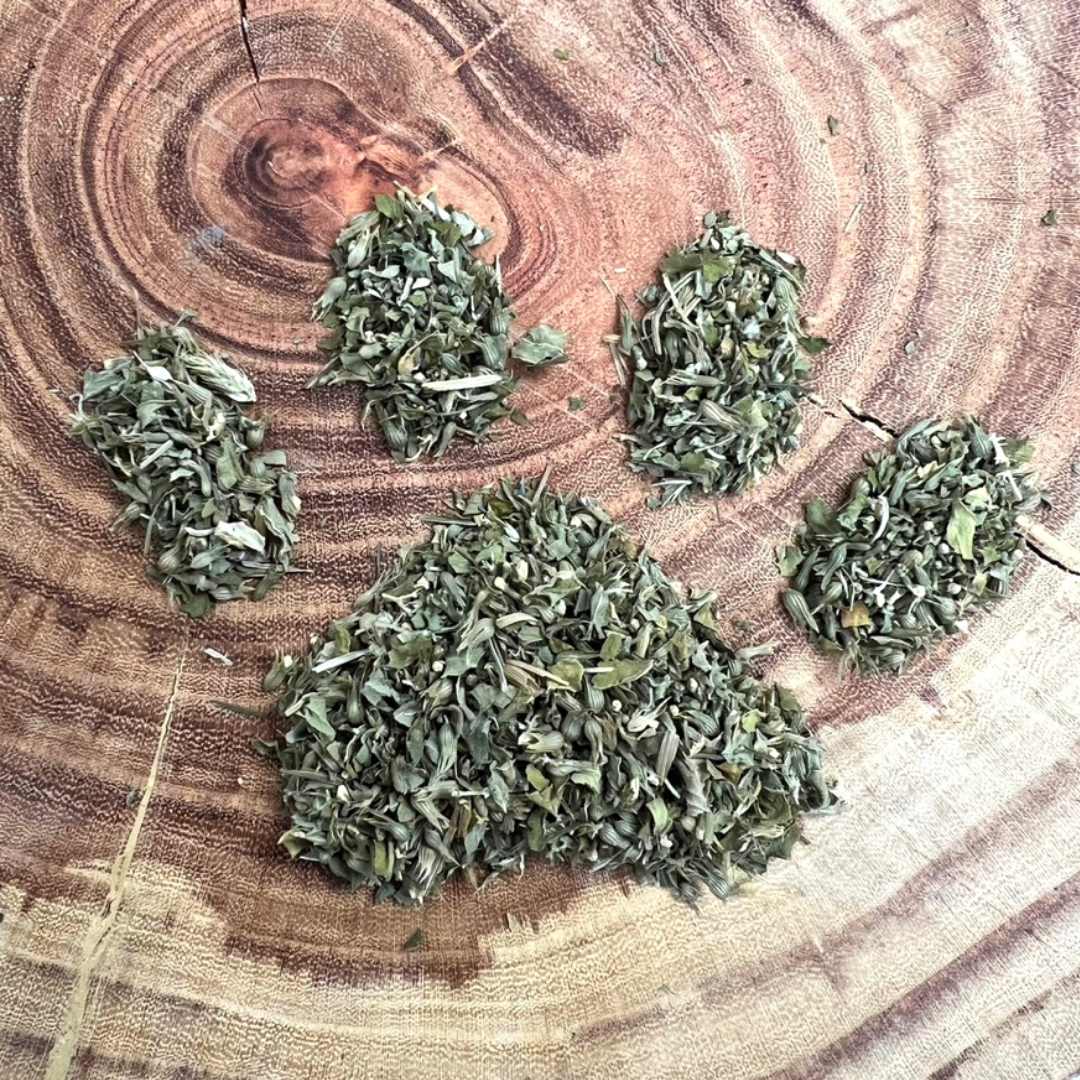 Bulk organic, seed and stem free cat nip displayed loose shaped like a cat's paw on wood.