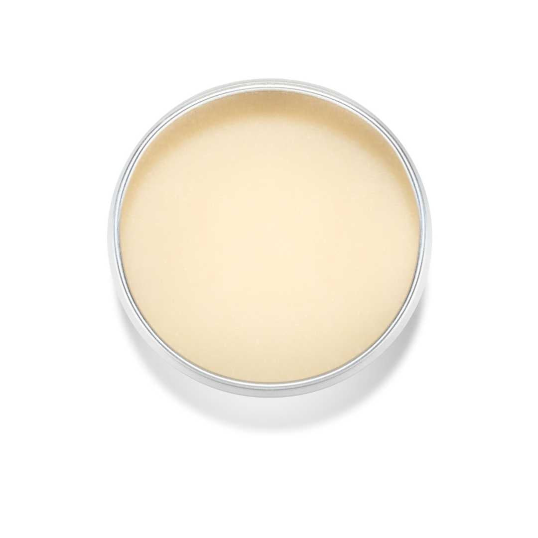 Open tin of 100% natural manuka honey lip balm in a tin with lid removed on a white background